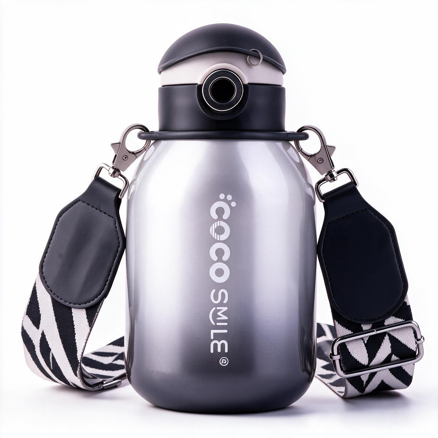 A large stainless steel water bottle with a black flip-top lid and a black-and-white patterned shoulder strap, shown on a clean white background. The bottle features the brand name 'coco smile' printed vertically on the front.